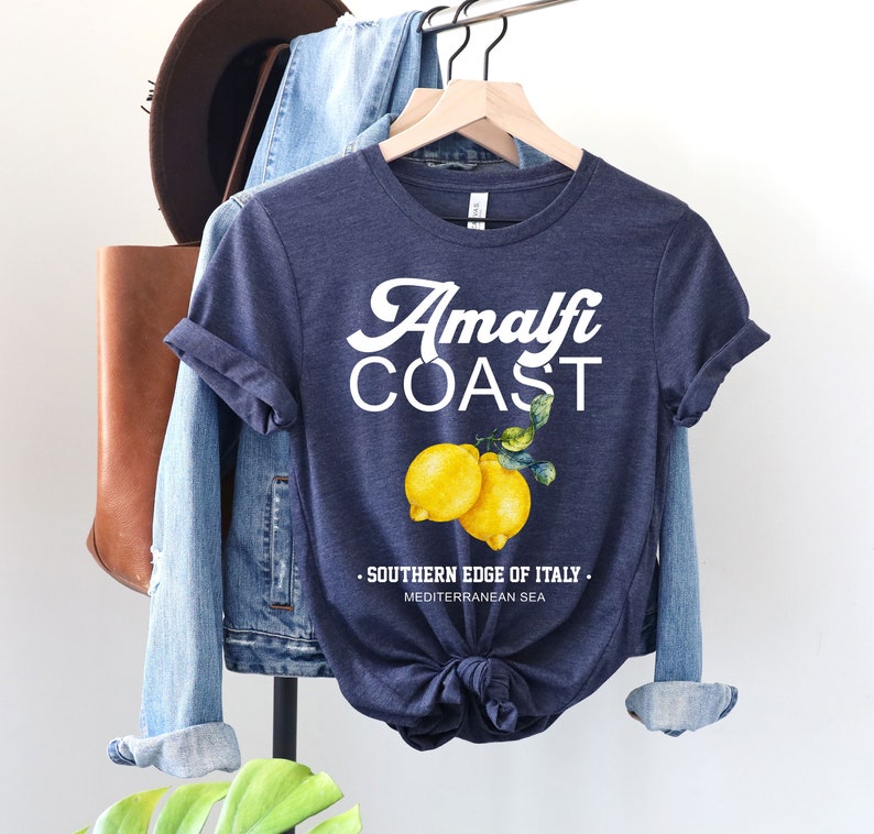 K&ouml;nnte beinhalten: Ein marineblaues T-Shirt mit wei&szlig;em Text, der "Amalfi Coast" lautet, und einer Grafik mit zwei Zitronen. Der Text unter den Zitronen lautet "S&uuml;dlicher Rand von Italien. Mittelmeer."