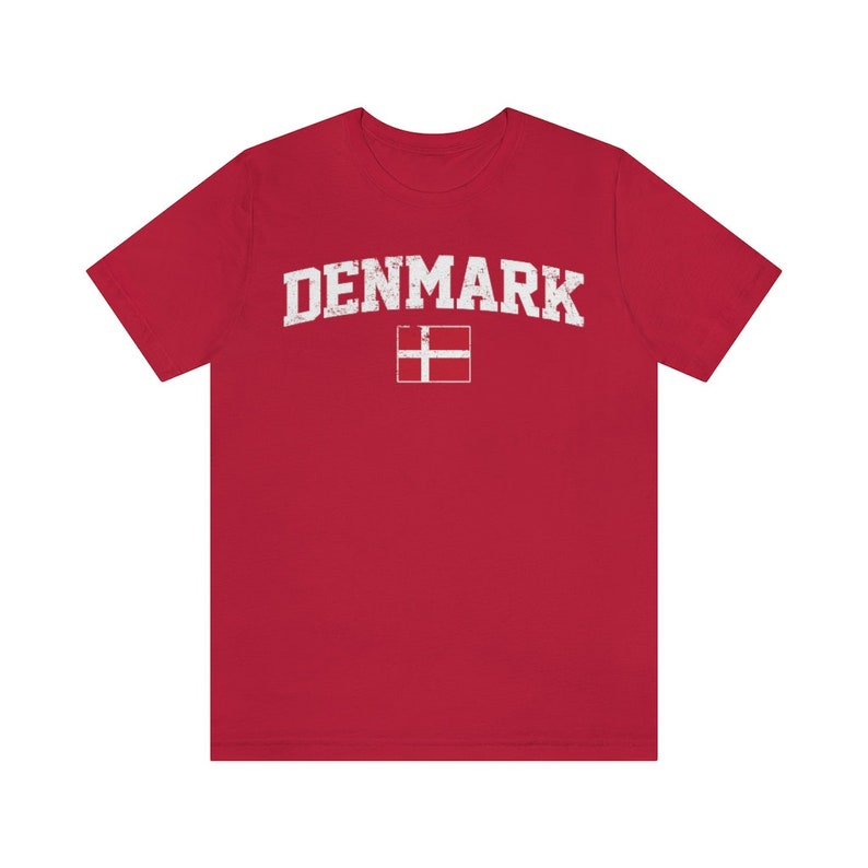 K&ouml;nnte beinhalten: Rotes T-Shirt mit einem wei&szlig;en, abgenutzten Aufdruck des Wortes "DENMARK" und der d&auml;nischen Flagge.
