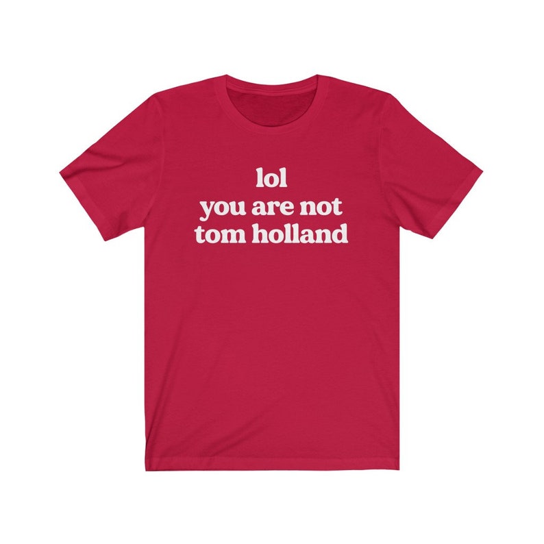 May include: Red short-sleeved t-shirt with white text that reads "lol you are not tom holland".