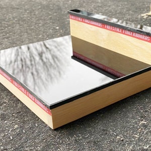 Puede incluir: Una rampa de fingerboard de madera con una superficie negra reflectante. La rampa está etiquetada con "I Freestyle Fingerboards".