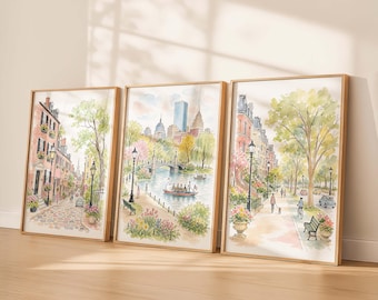 May include: A set of three framed watercolor prints depicting Boston city scenes. The artwork features brownstone buildings, the Public Garden with a swan boat on the pond, and tree-lined streets with pedestrians, benches, and street lamps.