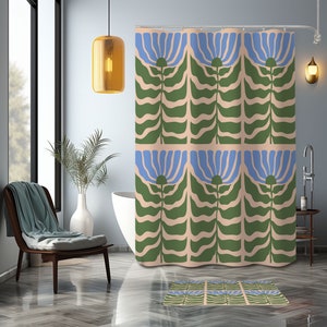 Könnte beinhalten: Ein Duschvorhang mit einem sich wiederholenden Muster aus stilisierten blauen Blumen und grünen Blättern auf einem hellrosa Hintergrund. Eine passende Badematte ist ebenfalls abgebildet.