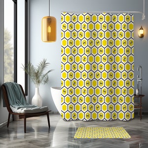 May include: A white shower curtain with a yellow honeycomb pattern and black bees. The shower curtain is hanging in a bathroom with a white bathtub and a brown chair.