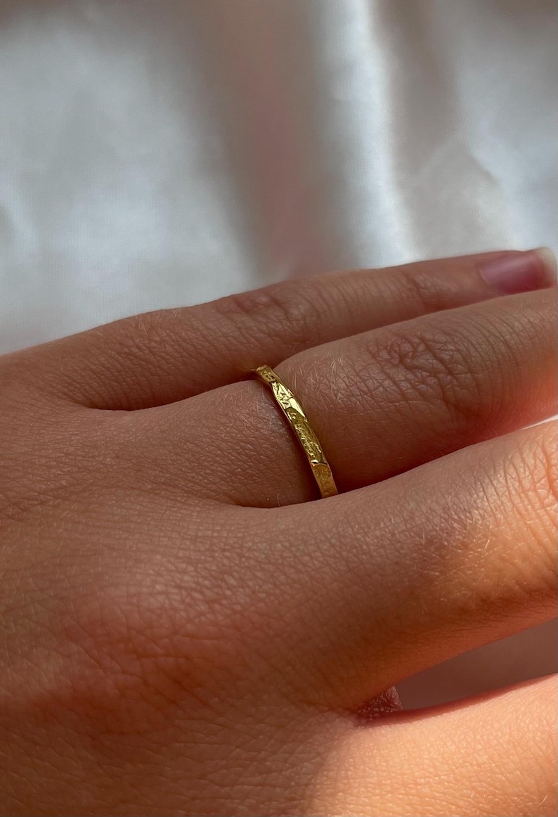 Pu&ograve; includere: Un sottile anello a fascia d'oro con una superficie testurizzata.
