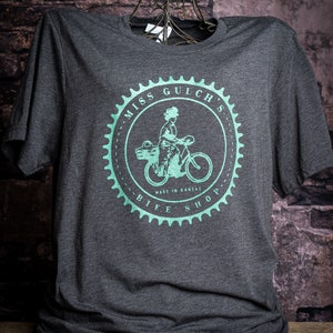 Miss Gulch&#39;s Bike Shop - Pearlized Green screen print on cotton/polyester blend t-shirt in dark gray