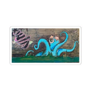 May include: A sticker featuring a whimsical illustration of a blue octopus with star-shaped eyes and tentacles. The octopus is emerging from green water, with Japanese text and other graphic elements in the background. The artwork has a hand-drawn aesthetic.
