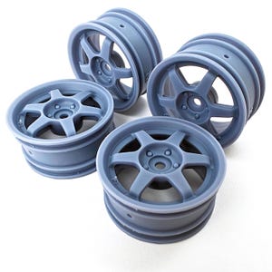 May include: Set of four gray plastic wheels with a six-spoke design. The wheels are designed for use with remote-controlled cars.