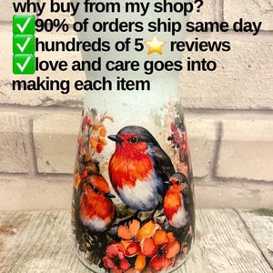 May include: A white ceramic vase with a robin design. The vase has a distressed look and features three robins perched on branches with red flowers. The text "why buy from my shop?" is written above the vase. The text "90% of orders ship same day" is written below the vase. The text "hundreds of 5 stars reviews" is written below the vase. The text "love and care goes into making each item" is written below the vase.
