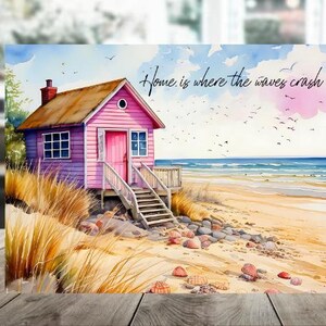 May include: Watercolor painting of a pink beach house with a brown roof, a door, and a small deck. The house is on a sandy beach with seashells and rocks. The text "Home is where the waves crash" is written in cursive.