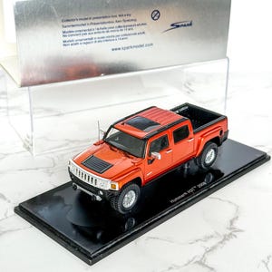 Può includere: Modellino di un pick-up Hummer H3T 2008 rosso, presentato su una base nera e in una scatola argentata. Il modellino presenta dettagli come ruote, tetto apribile e cassone nero. Articolo da collezione.