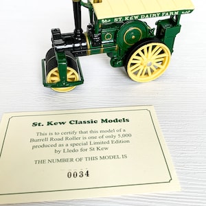 May include: A green and yellow toy model of a Burrell Road Roller, a steam-powered road roller. The model is labelled "St. Kew Dairy Farm" and has a certificate stating it is one of 5,000 limited edition models produced by Lledo for St. Kew. The certificate number is 0034.