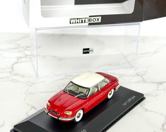 May include: A red and white Panhard 24 BT 1964 model car on a black display stand. The model is in a clear plastic case with a white box labeled "WHITEBOX". The model is 1 of 1,000 pieces.