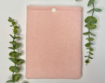 May include: A pink corduroy book cover with a white button closure.