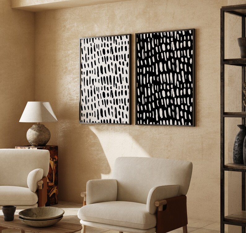 Puede incluir: Dos impresiones art&iacute;sticas abstractas enmarcadas. Cada impresi&oacute;n presenta un patr&oacute;n en blanco y negro de pinceladas verticales. Los marcos son negros. El arte se exhibe en una habitaci&oacute;n con muebles y decoraci&oacute;n de tonos neutros.