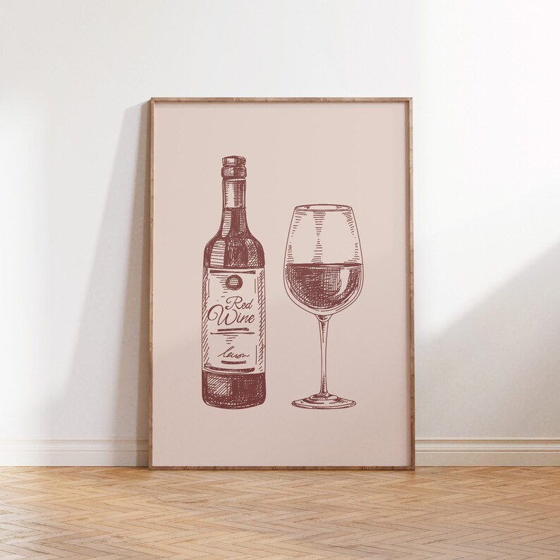 May include: A framed print featuring a sketch of a wine bottle and a wine glass filled with red wine. The bottle has a label that reads "Red Wine". The artwork is in shades of brown and is set against a light pink background.
