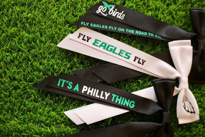 May include: Black and white ribbon bows with green text. The text on the ribbons reads "go birds", "FLY EAGLES FLY ON THE ROAD TO VICTORY", "FLY EAGLES FLY", and "IT'S A PHILLY THING".