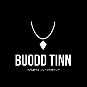 May include: A white graphic logo on a black background featuring a stylized necklace icon with a diamond-shaped pendant. Below the icon, the text reads BUODD TINN in a bold, sans-serif font, followed by the phrase SOMETHING DIFFERENT in quotes.
