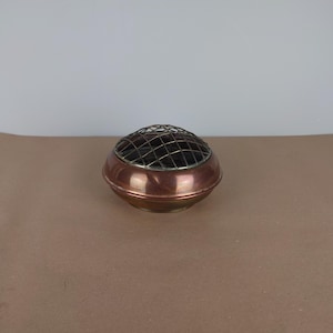 Peut inclure: Un brûle-encens rond en cuivre et en laiton avec un dessus en grillage.