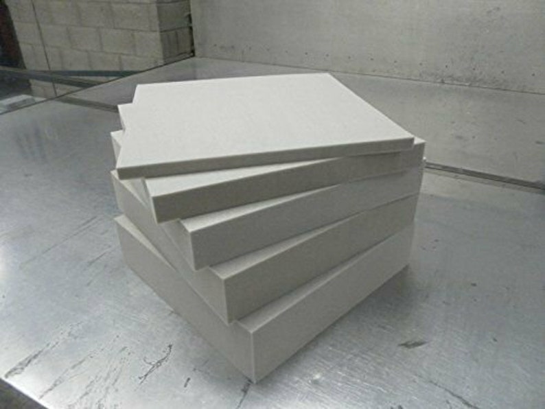 May include: A stack of five white foam squares. The squares are all the same size and are stacked on top of each other.