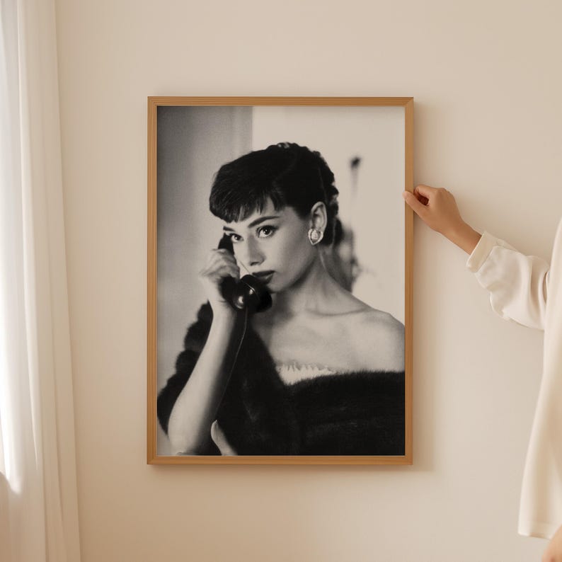 Peut inclure: Photographie en noir et blanc d'une femme aux cheveux courts et fonc&eacute;s, portant un col en fourrure, parlant au t&eacute;l&eacute;phone.