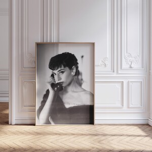 Peut inclure: Photographie en noir et blanc d'une femme aux cheveux courts, v&ecirc;tue d'une robe sombre, parlant au t&eacute;l&eacute;phone.