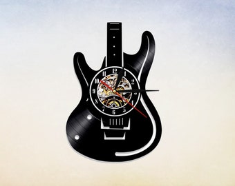 Könnte beinhalten: Schwarze, gitarrenförmige Wanduhr mit Zifferblatt und Zeigern. Das Zifferblatt hat römische Ziffern und ein zahnradförmiges Design.