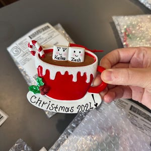 Christmas 2025, a charming keepsake featuring your loved ones’ names on smiling marshmallows. This Custom Marshmallow Family Ornament – Holiday 2025 Keepsake is perfect for cozy Christmas vibes and makes a great addition to your tree. Designed as a Christmas Mug Ornament with Names – Family of 5 – 2025,  Our Hot Chocolate Family Ornament – Christmas Tree Decor 2025 Ornament this listing.