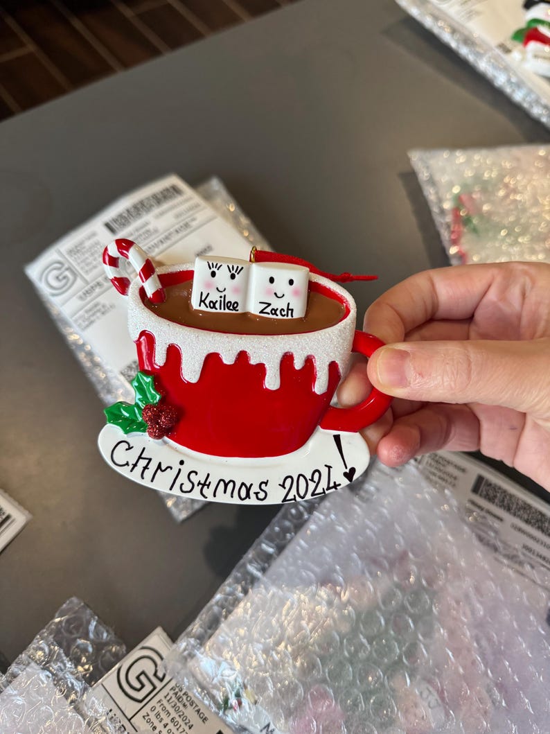 Christmas 2025, a charming keepsake featuring your loved ones’ names on smiling marshmallows. This Custom Marshmallow Family Ornament – Holiday 2025 Keepsake is perfect for cozy Christmas vibes and makes a great addition to your tree. Designed as a Christmas Mug Ornament with Names – Family of 5 – 2025,  Our Hot Chocolate Family Ornament – Christmas Tree Decor 2025 Ornament this listing.