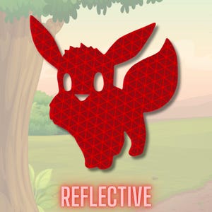 May include: A red reflective sticker featuring the silhouette of a stylised creature with large pointed ears and a bushy tail. The surface has a repeating triangular pattern. The word REFLECTIVE is printed in red capital letters at the bottom.