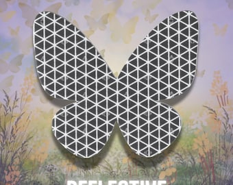 May include: A butterfly-shaped decal featuring a dark gray surface with a white geometric grid pattern of repeating triangles. The word REFLECTIVE is printed in white capital letters at the bottom of the butterfly-shaped graphic element.