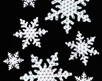 May include: A black background with seven white snowflake cutouts. The snowflakes are all different sizes and have a geometric design.