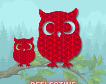 May include: Two red owl silhouettes with a geometric triangular pattern perched on a tree branch. The larger owl is on the right and the smaller owl is on the left. The word REFLECTIVE is printed in large, bold, light-coloured capital letters below.