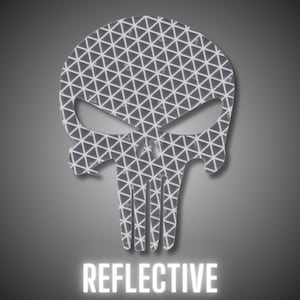 Könnte beinhalten: Reflektierender Aufkleber in Schädelform mit geometrischem Muster. Das Design ist grau und weiß, mit dem Wort "REFLECTIVE" in weißen Blockbuchstaben unten. Der Aufkleber ist wahrscheinlich für Fahrzeuge oder Sicherheitsanwendungen.
