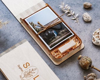 May include: A wooden box with a photo of a couple on the top and a USB drive inside. The box is engraved with the names "Sophia" and "Liam" and the date "2022.10.28".