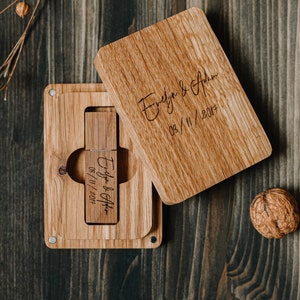 Può includere: Una scatola di legno con un coperchio scorrevole, incisa con i nomi "Evelyn & Adam" e la data "03/11/2017". All'interno della scatola c'è un'unità USB in legno con la stessa incisione.
