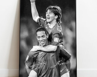 Puede incluir: Impresión enmarcada en blanco y negro que presenta a dos futbolistas, uno llevando al otro sobre sus hombros. Ambos llevan camisetas y sonríen. La impresión incluye firmas y está sobre un fondo borroso.