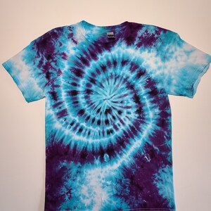 May include: A tie-dye t-shirt with a blue and purple spiral pattern.