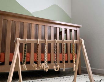 Gimnasio de juegos de madera para bebés, estilo Montessori con juguetes de macramé.