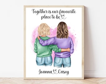 May include: A framed print featuring two figures with arms around each other, set against a pink heart backdrop. The text reads "Together is our favourite place to be" and includes the names "Joanna" and "Casey". The figures are wearing casual clothing.