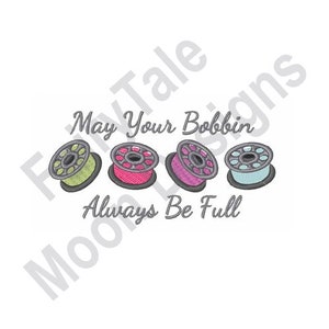 Peut inclure: Un motif de broderie avec le texte "May Your Bobbin Always Be Full" et quatre bobines de fil colorées.