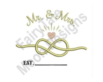 May include: A yellow embroidered design of a knot with a heart above it. The text "Mr. & Mrs." is above the knot and the text "EST." is below the knot.