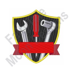 May include: Embroidered patch featuring a shield design with a wrench, screwdriver, and socket wrench. The shield has a black background with a gold border and a red banner at the bottom. The tools are silver and the screwdriver is red.