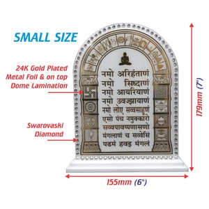 Puede incluir: Un arco enmarcado en blanco con detalles dorados y fondo blanco. El arco está decorado con símbolos dorados y blancos y texto en idioma hindi. El arco mide 15,2 cm de ancho y 17,8 cm de alto. El marco está decorado con cristales transparentes.
