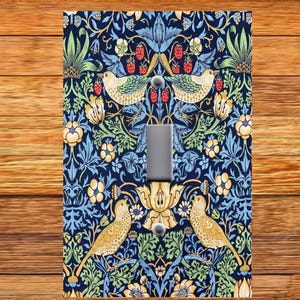 May include: A light switch cover with a floral pattern in shades of blue, green, yellow, and red. The pattern features birds, leaves, and flowers.