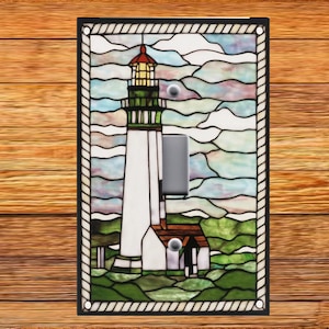 May include: A stained glass light switch cover featuring a lighthouse with a white tower, a brown roof, and a green lantern. The lighthouse is surrounded by blue and green stained glass waves and clouds.