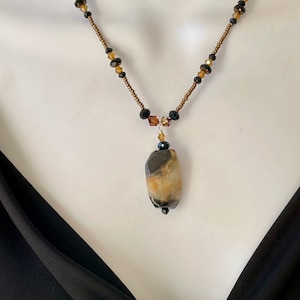 Black/Bronze/Lt. Blue agate nugget pendant with Black and brown different sized crystals and Bronze seed beads