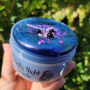 May include: A blue slime with black and pink glitter in a clear container with a white label that says "Deadly Night Shade".
