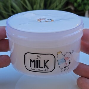 May include: A white plastic container of 2% milk with a cartoon cow and milk carton on the label. The label reads "2% Milk", "Grade A", "Vitamin A & D", and "Do Not Eat".