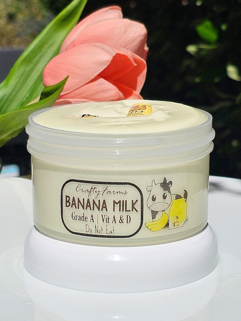 May include: A white jar with a yellow lid and a white label that says "Crafty Farms Banana Milk Grade A | Vit A & D Do Not Eat" with a cartoon cow and banana illustration.