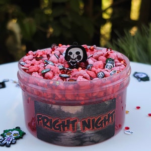 May include: Red slime with a black and white horror character charm, red and white sprinkles, and a black label that says "FRIGHT NIGHT".